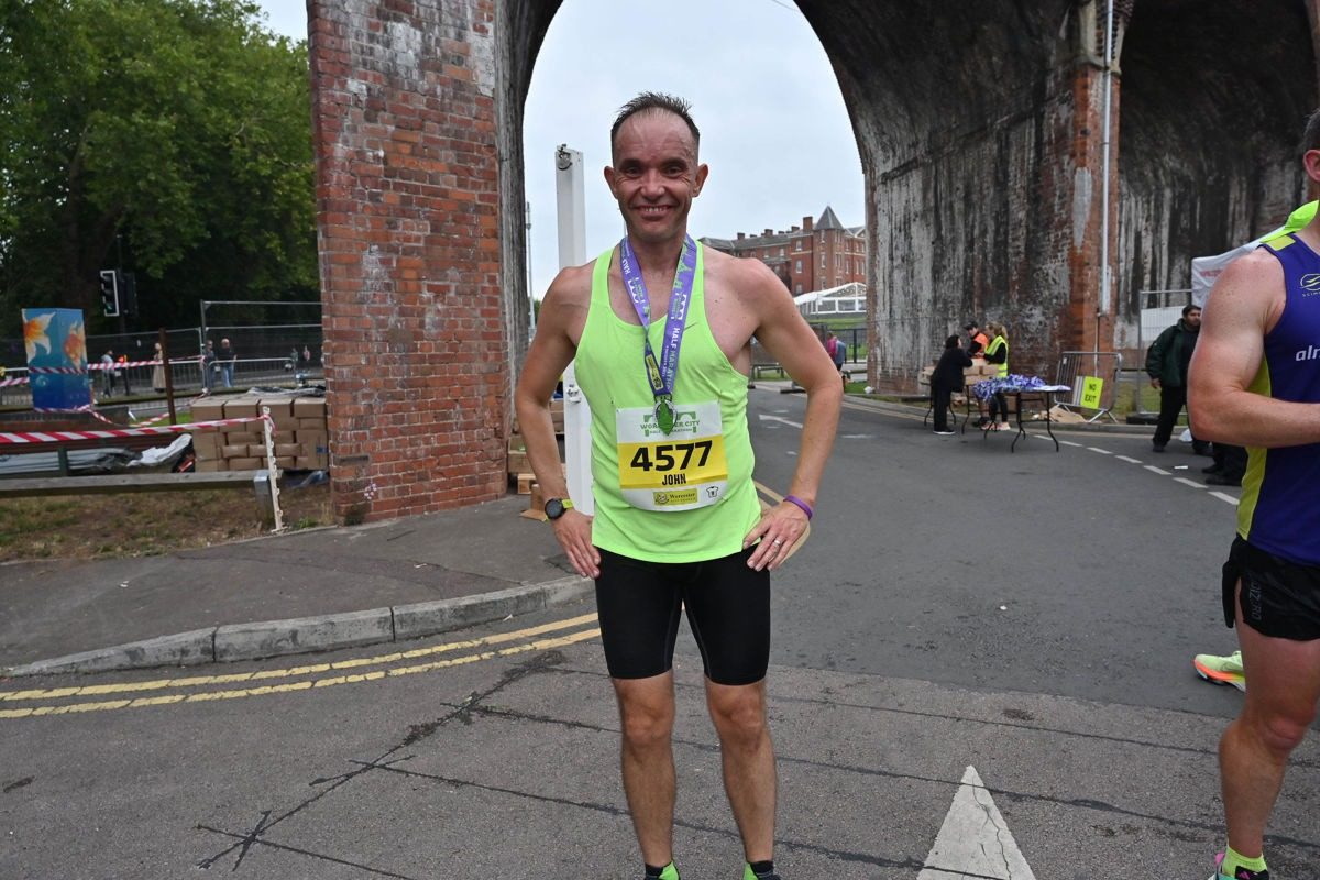 John standing with his marathon finisher medal